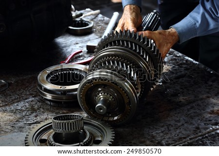 Engineer hands fixing engine power transmission gears box Royalty-Free Stock Photo #249850570