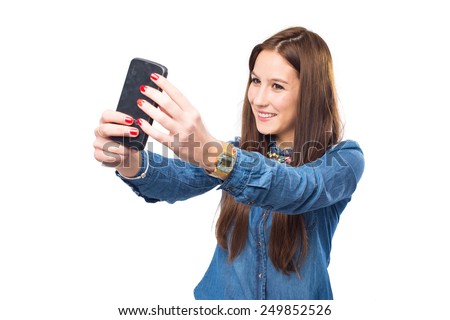 Trendy young woman using a smart phone to take a picture. Over white background