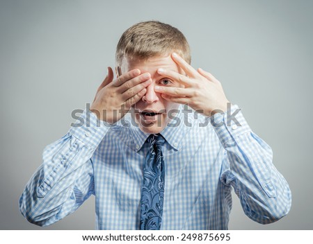 young man closes his eyes with his hands