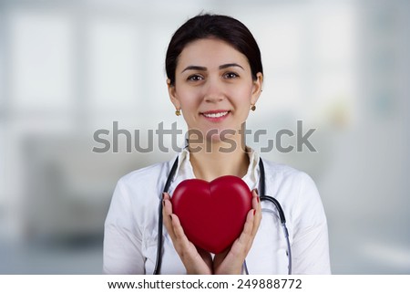 Smiling Female doctor holding red heart and a stethoscope.Medicine,Health care,Hospital.