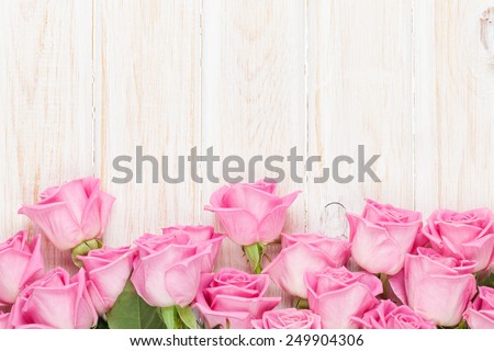 Valentines day background with pink roses over wooden table. Top view with copy space