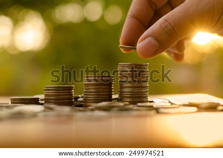 Saving money concept preset by Male hand putting money coin stack growing business Royalty-Free Stock Photo #249974521