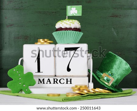 Happy St Patricks Day save the date white vintage wood calendar with cupcakes on vintage style green wood background.
