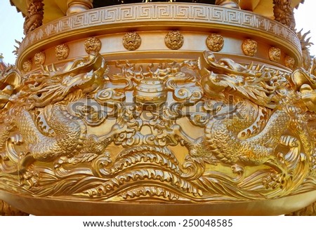 Golden dragon sculpture on incense burner in the public Chinese temple.