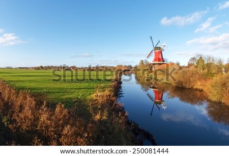 Greetsiel, Germany - December 6, 2014: Traditional Windmill working and still used to grind. The second mill is currently under renovation due to a violent hurricane. Royalty-Free Stock Photo #250081444