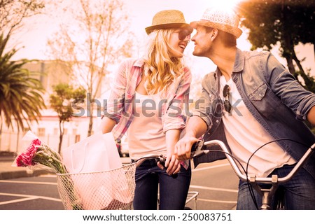 Hip young couple on a bike ride on a sunny day in the city