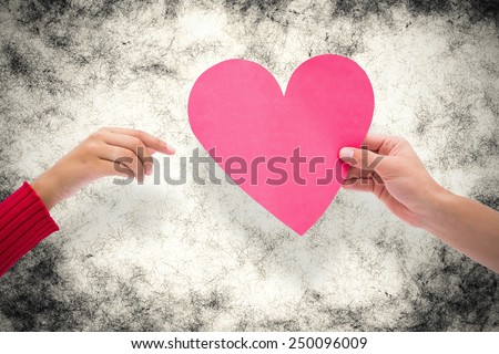 Couple holding a heart against grey background