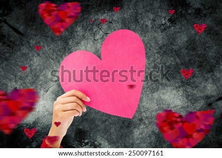 Couple holding a heart against hearts