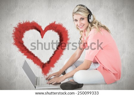 Young pretty student using laptop against white and grey background