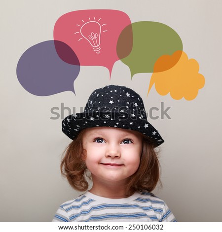 Happy kid thinking and looking up on idea bulb in bubble on grey background. Closeup portrait