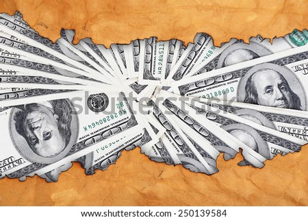 Dollars through torn craft paper