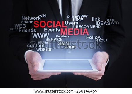 Businessman holding a tablet with social media words cloud on the screen. business  concept.