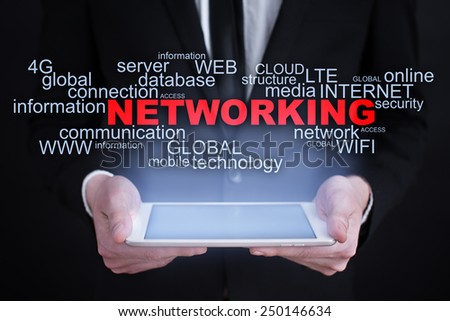 Businessman holding a tablet with networking words cloud on the screen. business  concept.