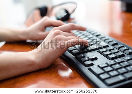 Close up picture on female hand at office desk and typing on keyboard