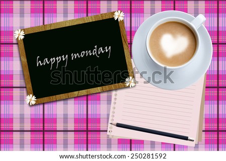    Happy Monday word and coffee cup on pink fabric  background.