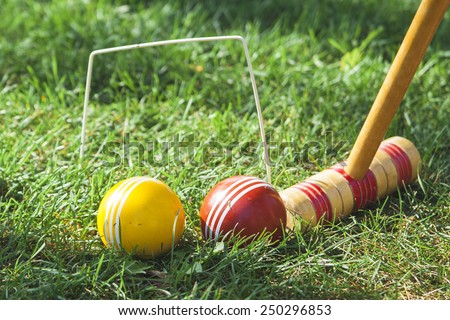 Croquet Mallet and Hoop with Red and Yellow Balls Royalty-Free Stock Photo #250296853
