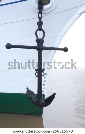 Sailing concept. Main anchor hanging on a white shipboard