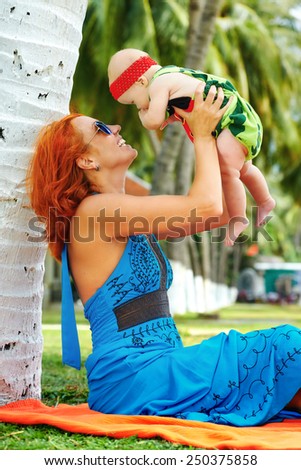 Beautiful Mother And Baby outdoors. Nature. Beauty Mum and her Child playing in Park