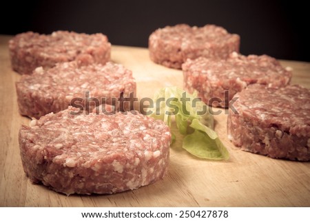 Raw cutlet of minced meat on a wooden cutting board. Toned.