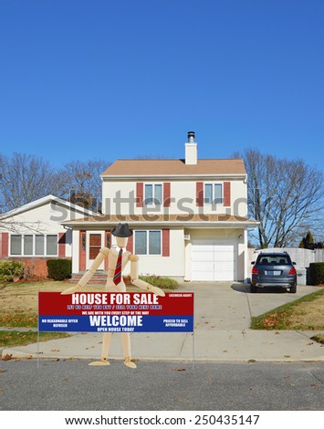 Mannequin wearing businessman attire holding Real estate for sale open house welcome sign Suburban home burnt dry front yard lawn blue sky residential neighborhood autumn day USA
