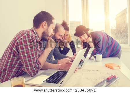Young group of people/architects discussing business plans. Royalty-Free Stock Photo #250455091