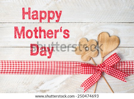 Happy Mothers Day - flower and heart with red ribbon on wooden background