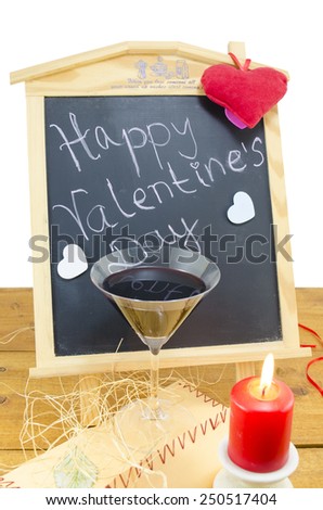 Blackboard with the words Happy Valentines written on it, decorated with hearts, a candel and a wine glass