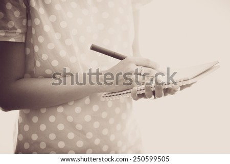 Young female is writing notes and planning her schedule