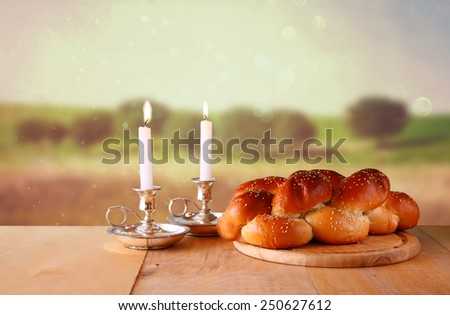 Sabbath image. challah bread and candelas on wooden table 