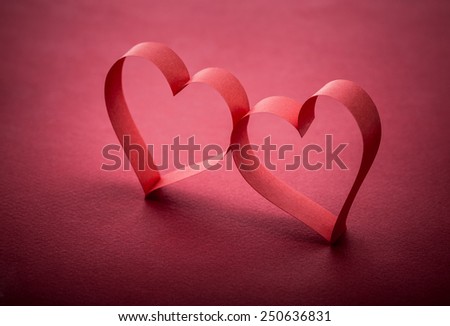 two beautiful romantic heart, made of paper tape in the shape of heart on a red paper background - pictures concept theme Love and St. Valentine's Day