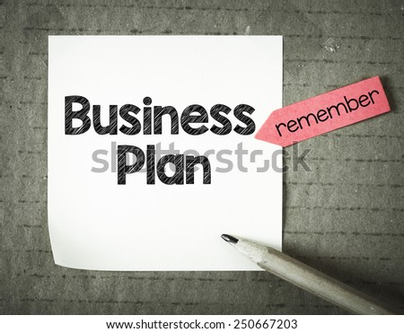 Note with business plan and pencil on grunge background