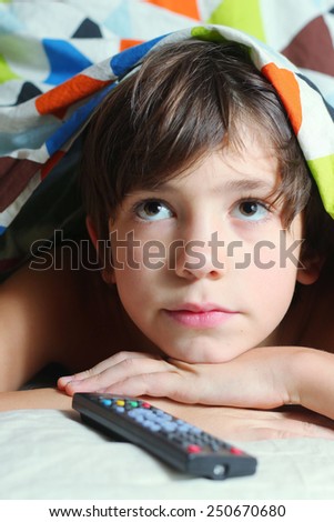 preteen handsome boy have a good time in bed watch tv