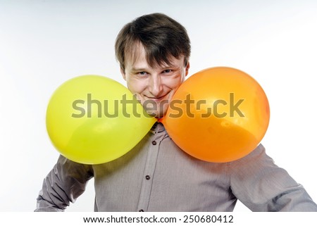 Young caucasian man holding yellow air balloons in his hand. Happy like a child.