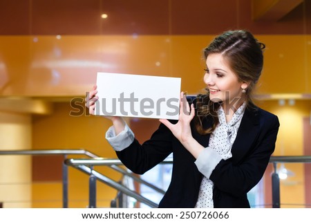 young beautiful woman looking at a blank white card