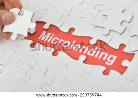 Close-up Of Microlending Text Under White Jig Saw Puzzle Royalty-Free Stock Photo #250759744