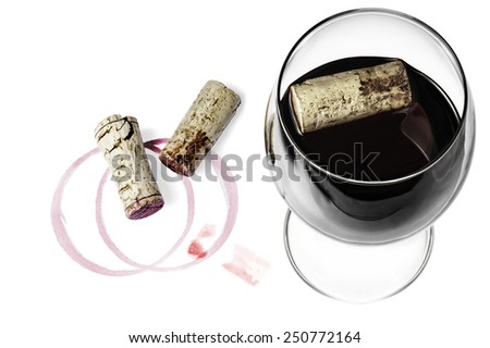 A wine glass, corks and wine imprints on a white background