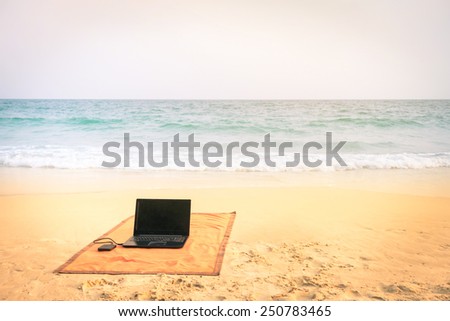 Computer laptop at the beach on tropical destination - Concept of internet connection and technology worldwide - Soft focus due to the vintage nostalgic filtered look - Vignetted filter