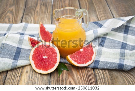 Grapefruit juice and grapefruit on wooden background