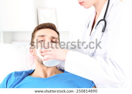 Doctor gives to drink patient close up