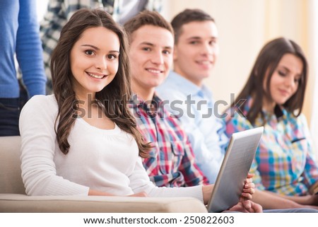 Education and people concept. Group of students are sitting on the sofa with laptop.