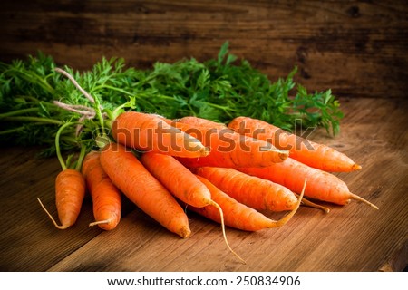 fresh carrots bunch on rustic wooden background Royalty-Free Stock Photo #250834906