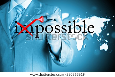 Businessman Hand turning the word Impossible into Possible with red marker 