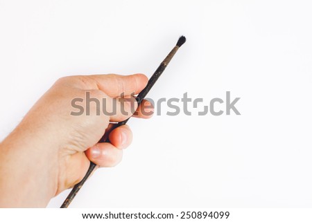 Hand holding brush isolated on white