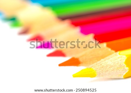 Colored pencils on an isolated background. Focus on the yellow pencil