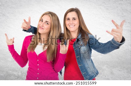 Students making horn gesture over textured background