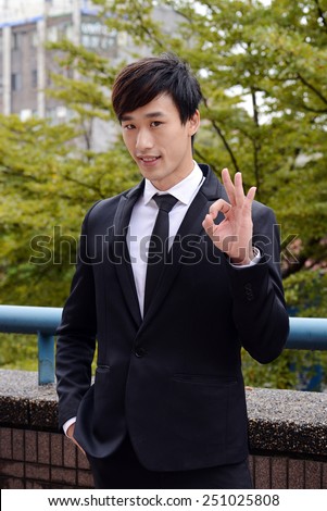 Successful business man shows ok hand sign
