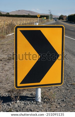 Warning safety chevrons on a rural New Zealand road indicating a bend in the road
