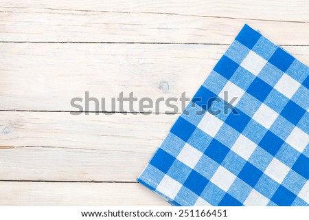 Blue towel over wooden kitchen table. View from above with copy space 