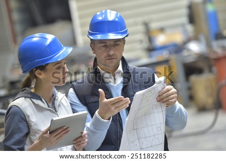 Engineers in mechanical factory reading instructions Royalty-Free Stock Photo #251182285
