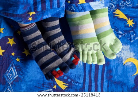 Stock photo: an image of two pairs of funny feet in striped socks